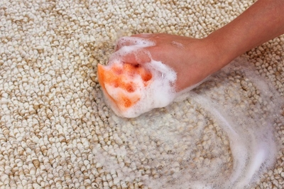Cleaning carpet with sponge with soap