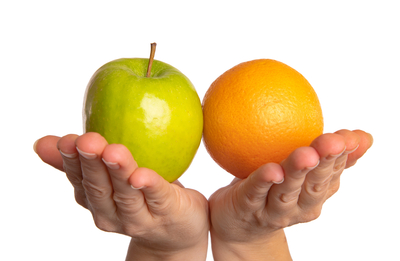 A person holding up an apple and orange in their hands