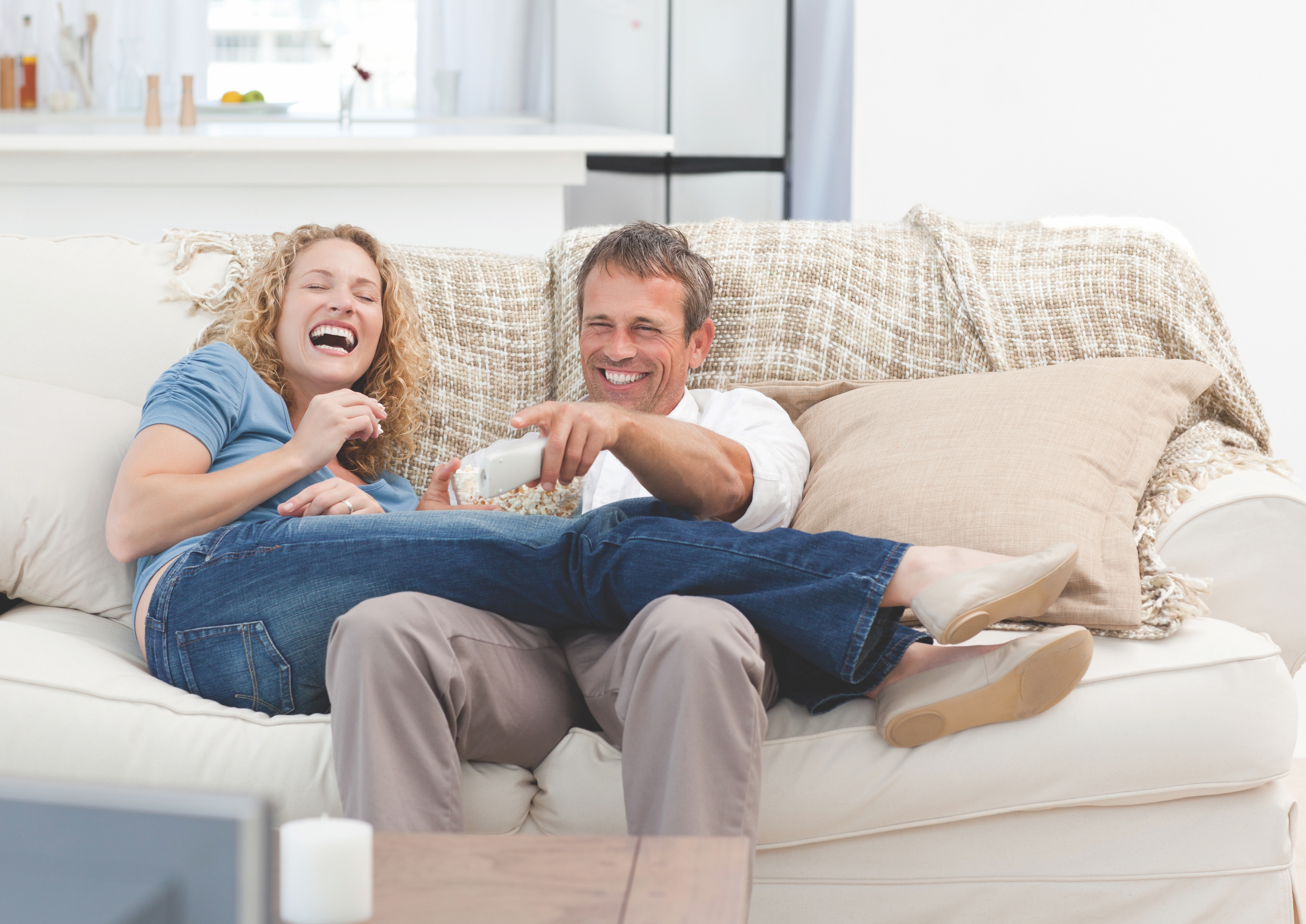 a couple laughing on the couch together